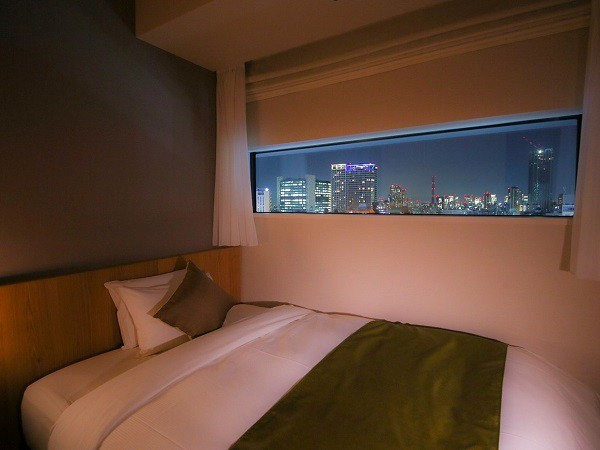 ホテルグレイスリー新宿 【シングルルームからの夜景(一例)】映画のフィルムをイメージした長方形の窓